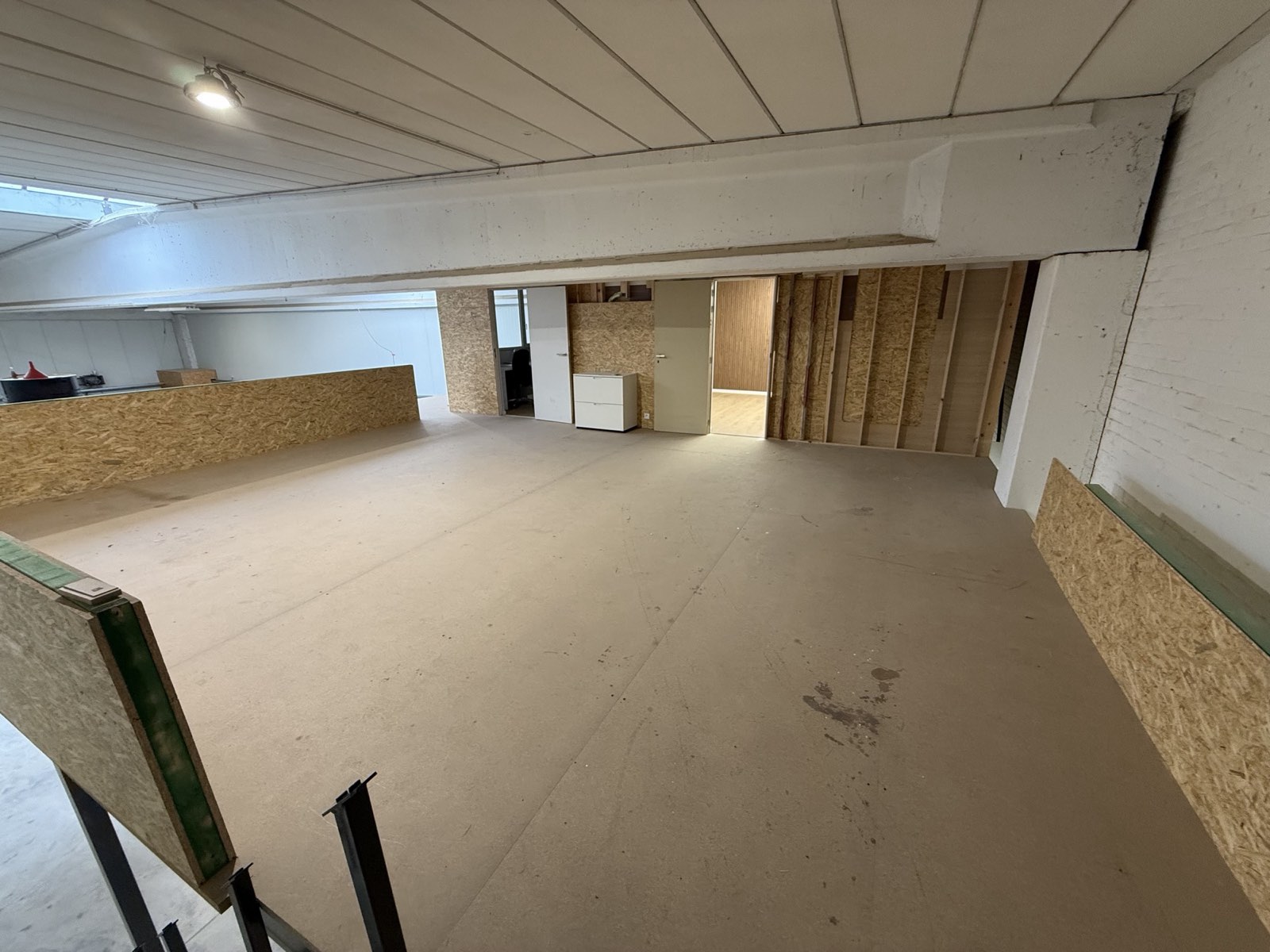 Tussenverdieping met witte balken en OSB-balustrade